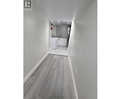 A long hallway with a kitchen in the distance.