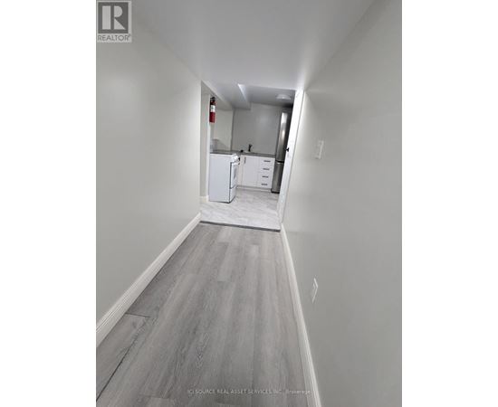 A long hallway with a kitchen in the distance.