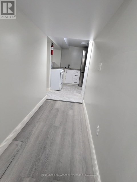 A long hallway with a kitchen in the distance.