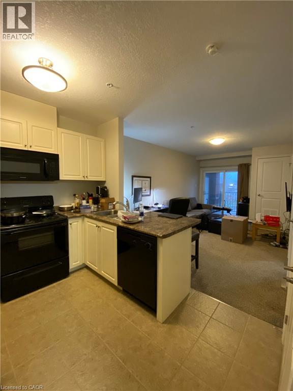 A kitchen with black appliances and white cabinets.