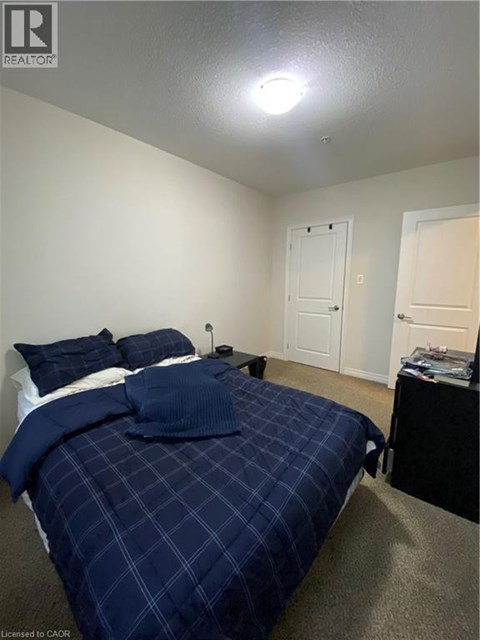 A bedroom with a bed covered in a blue comforter.