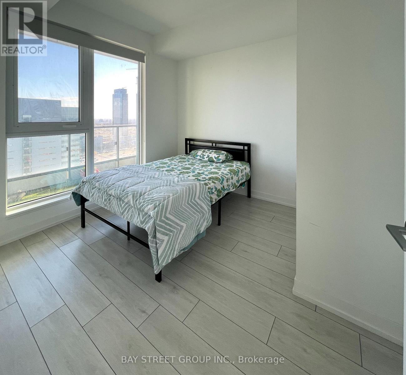 A bedroom with a large bed and a view of the city.