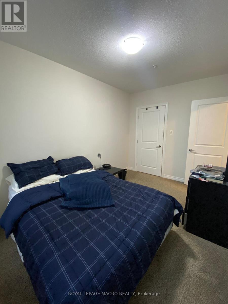 A bedroom with a bed covered in a blue comforter.