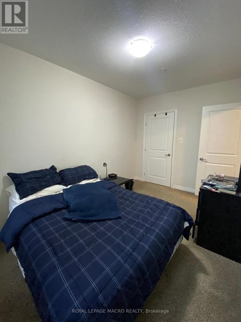A bedroom with a bed covered in a blue comforter.