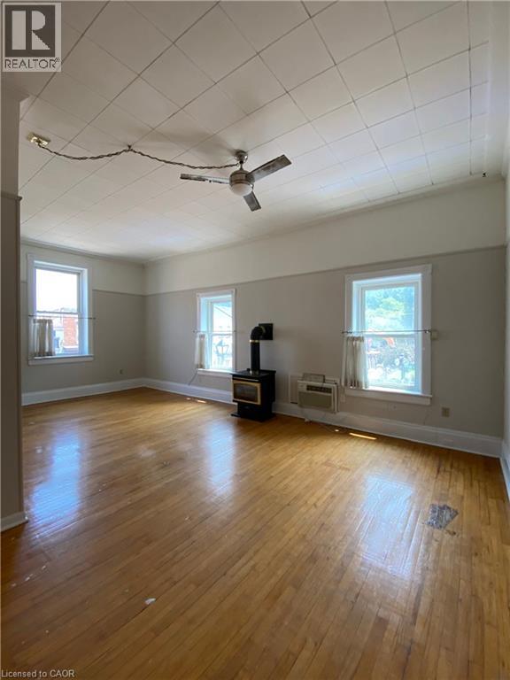 A room with a ceiling fan and wooden floors.