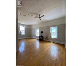 A room with a ceiling fan and wooden floors.