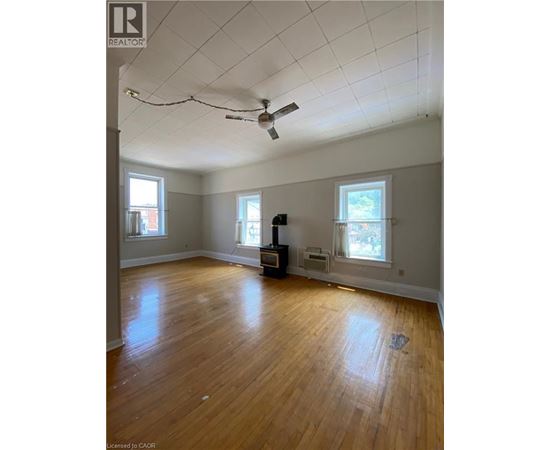 A room with a ceiling fan and wooden floors.