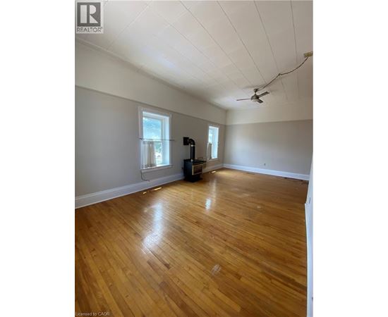 A room with wooden floors and a ceiling fan.