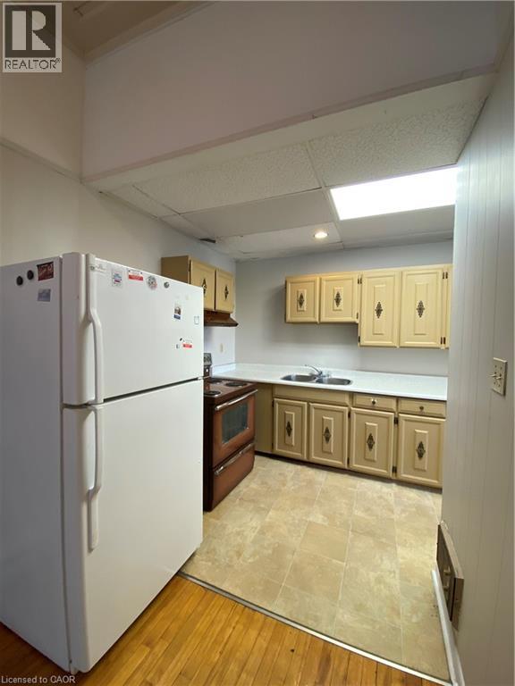 A kitchen with a white refrigerator and wooden cabinets.