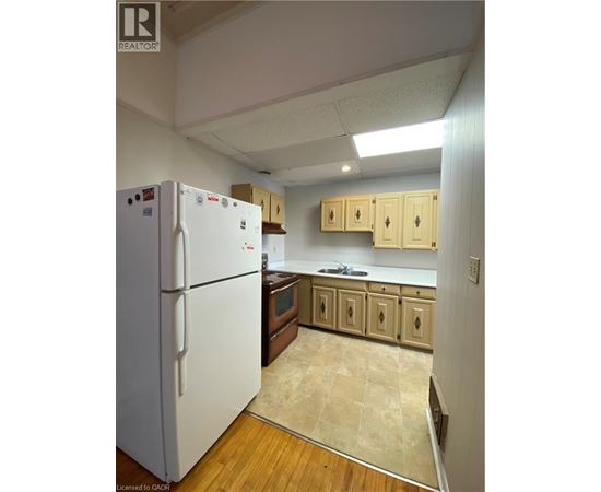 A kitchen with a white refrigerator and wooden cabinets.