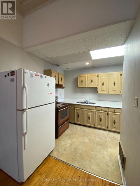 A white refrigerator is in a kitchen with wooden cabinets.