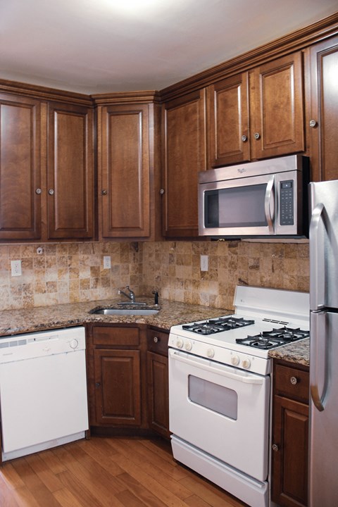 a kitchen with white appliances and wooden cabinets