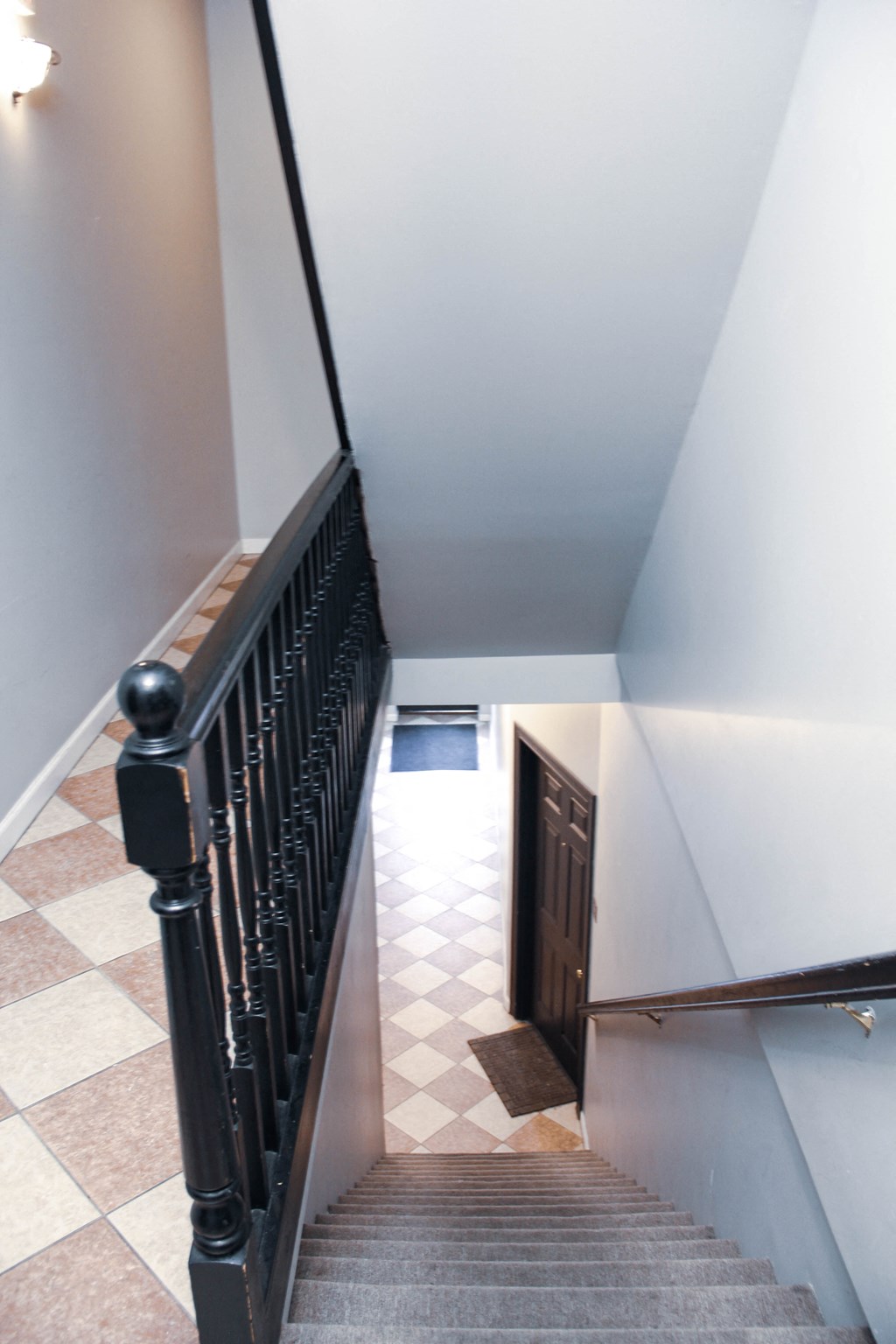 a view down the stairwell from the bottom of a staircase with a door in