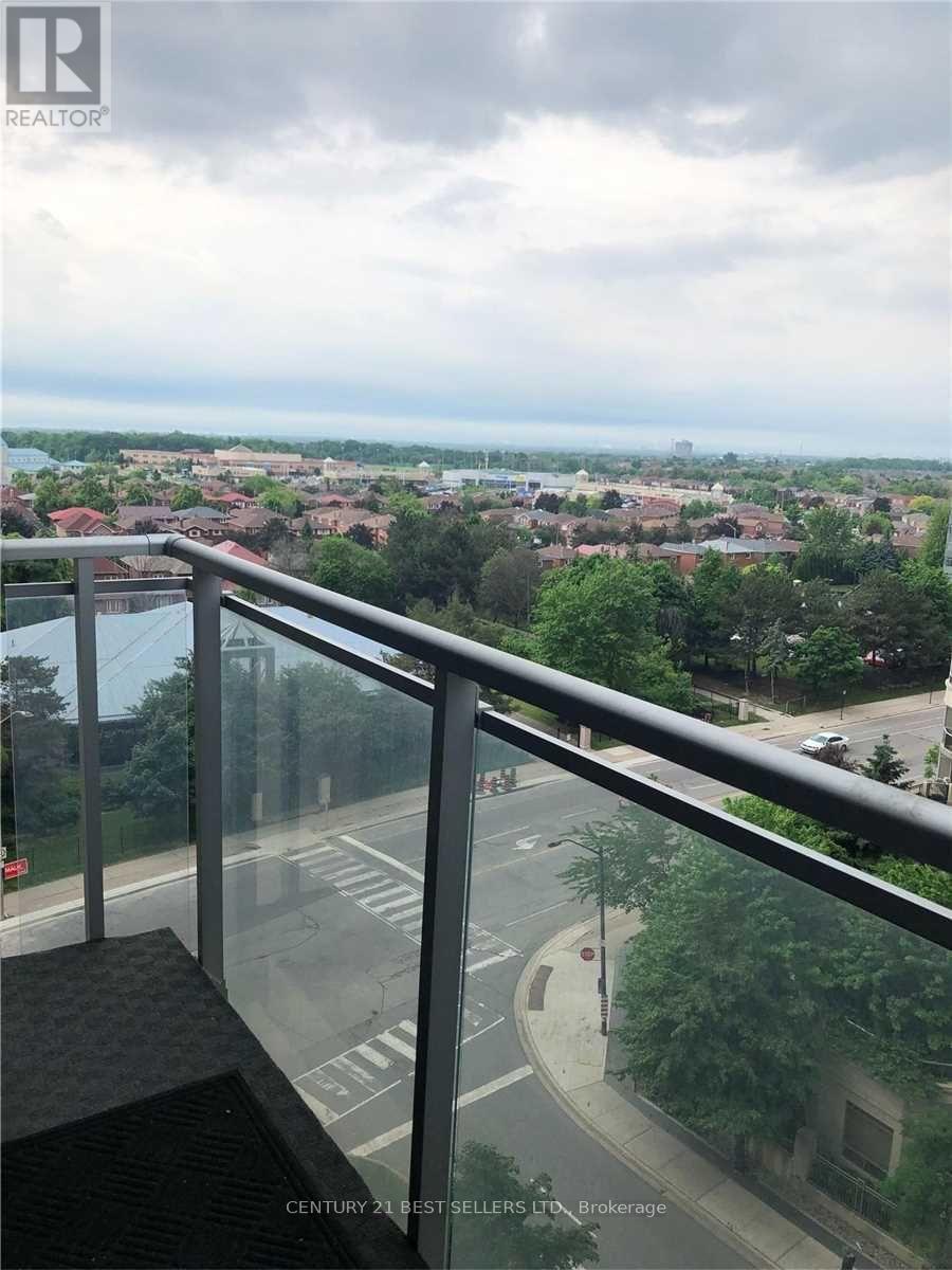 A balcony overlooks a street with cars and buildings.