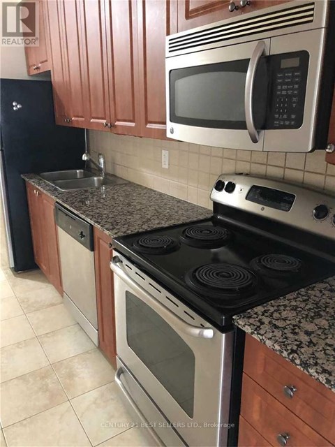 A kitchen with a stove top oven, microwave, and sink.