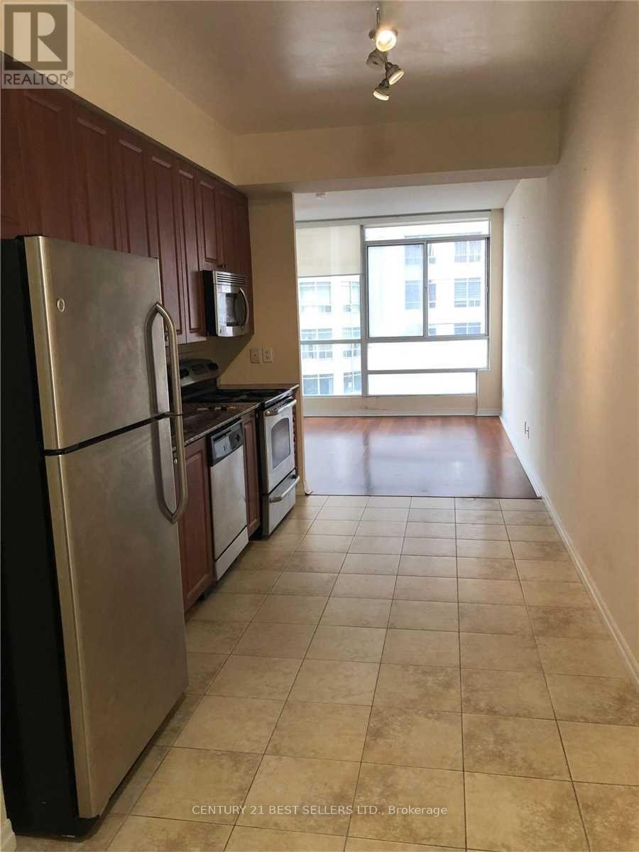 A kitchen with a refrigerator, microwave, and oven.