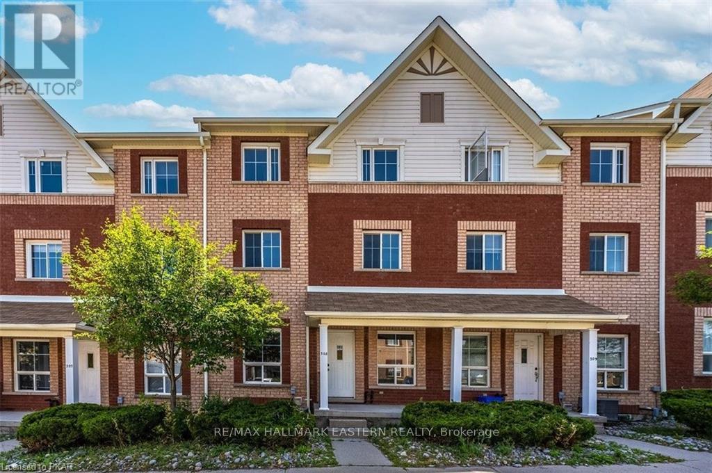 A large brick building with a tree in front and a sign that says RE/MAX Hallmark Estate Realty.