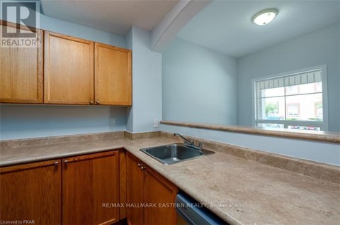 A kitchen with brown cabinets and a sink.