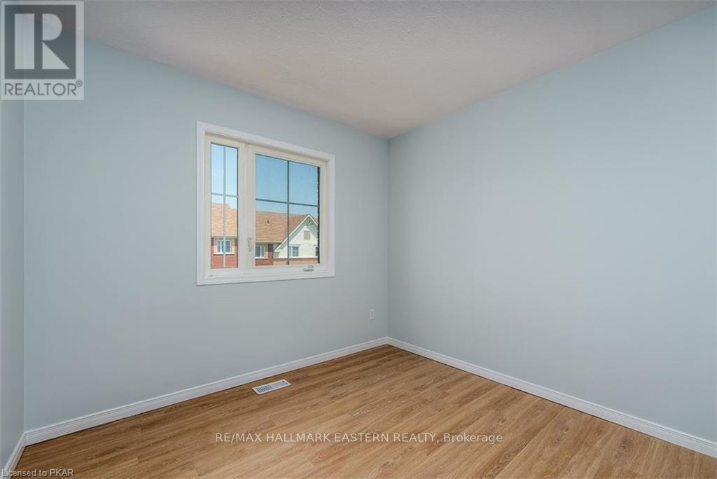 A room with a window showing a view of a house.
