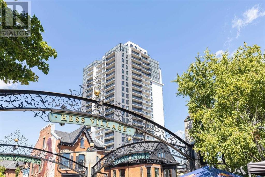 A street view of Hess Village with a tall building in the background.