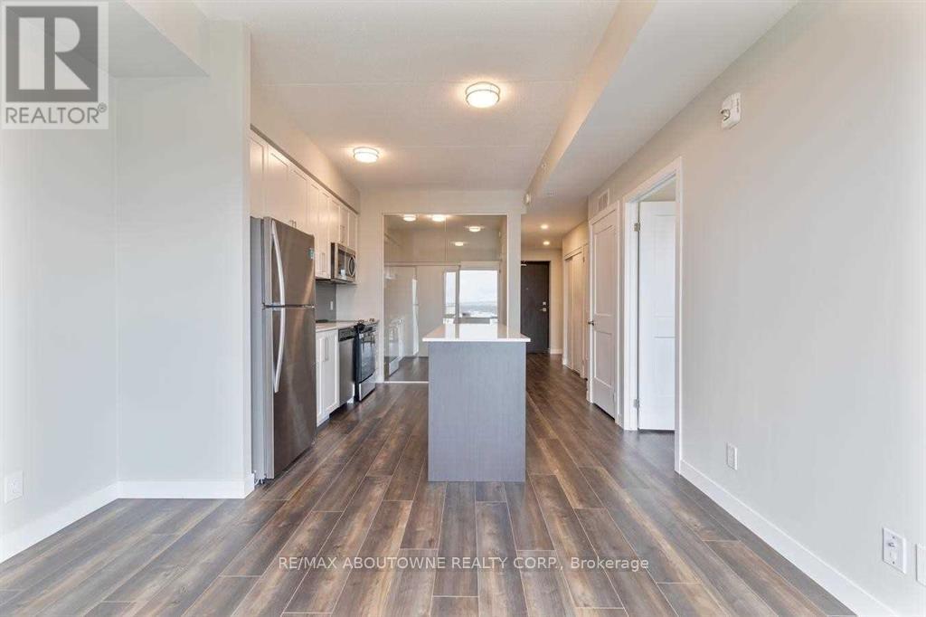 A spacious, empty room with wood flooring and white walls.