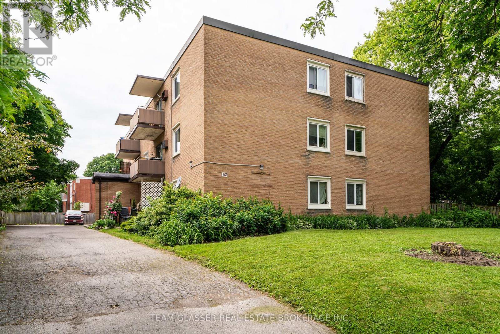 A brick building with a driveway in front of it.