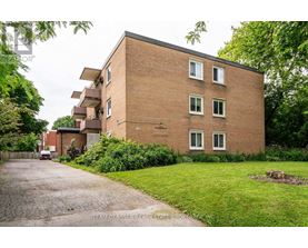 A brick building with a driveway in front of it.