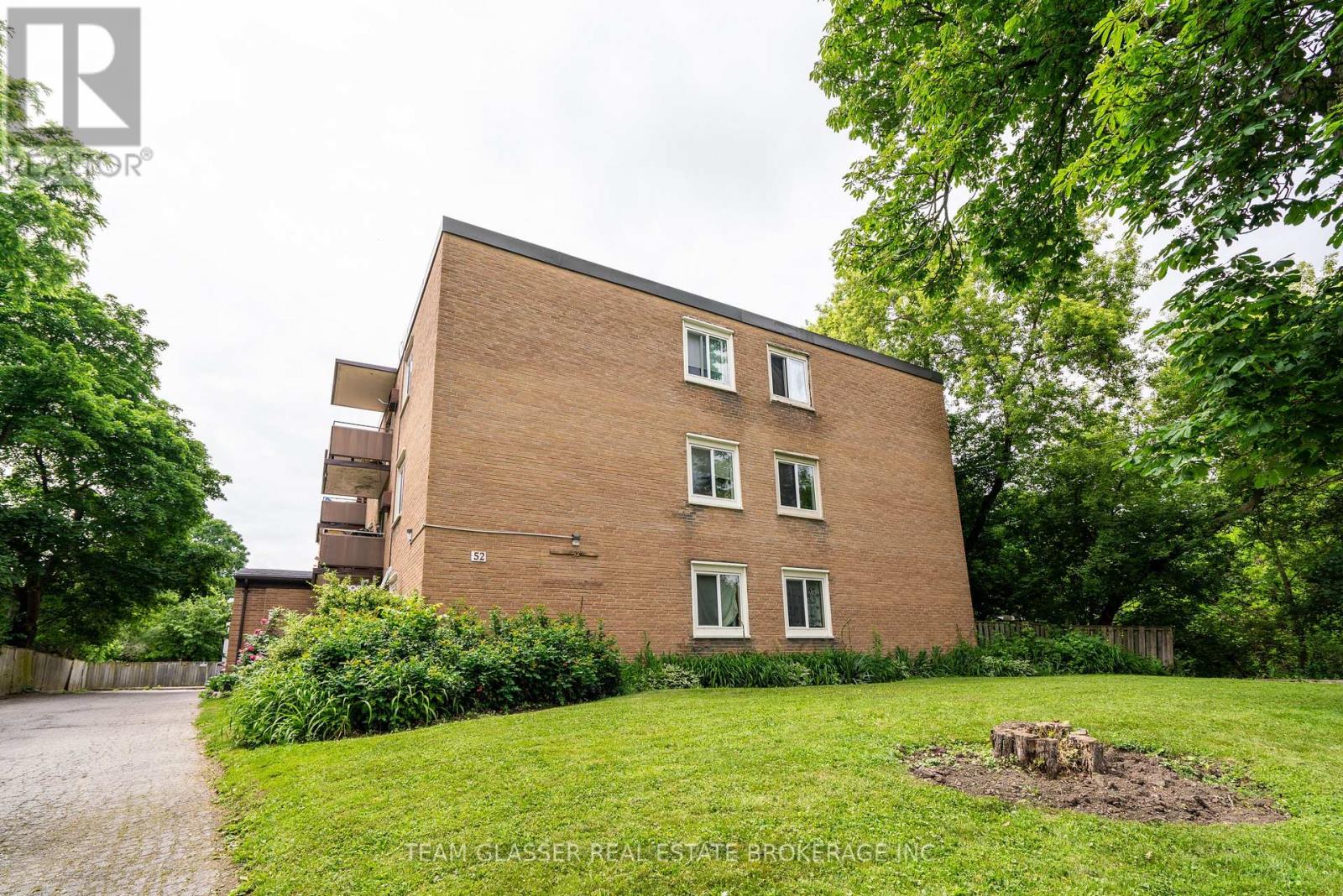 A brick building with a green lawn in front.