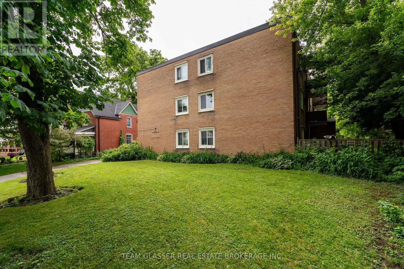 A brick building with a green lawn in front.