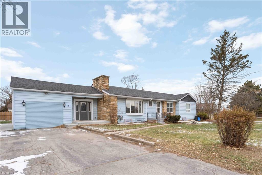 A blue house with a grey roof and a chimney is for sale.