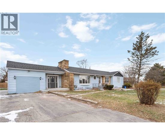 A blue house with a grey roof and a chimney is for sale.