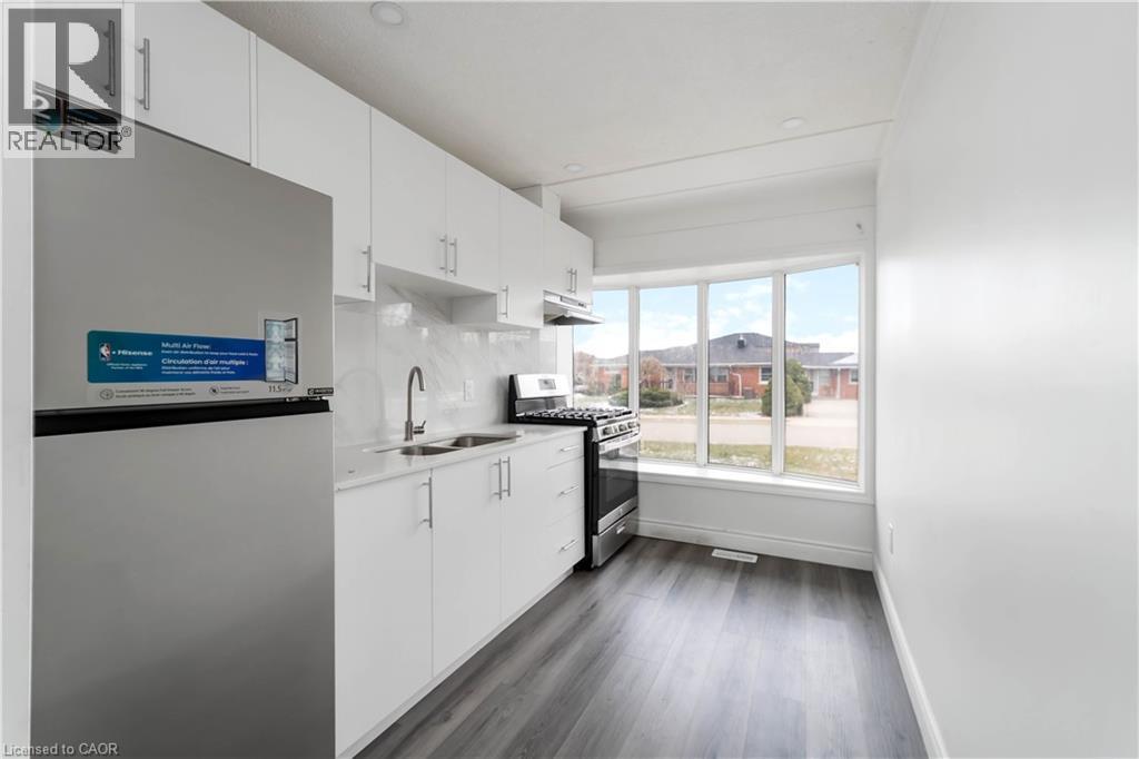 A kitchen with white cabinets and a black countertop.