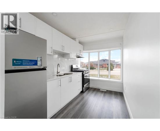 A kitchen with white cabinets and a black countertop.