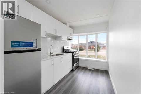 A kitchen with white cabinets and a black countertop.