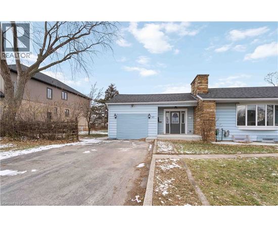 A blue house with a grey garage door is surrounded by a snowy landscape.