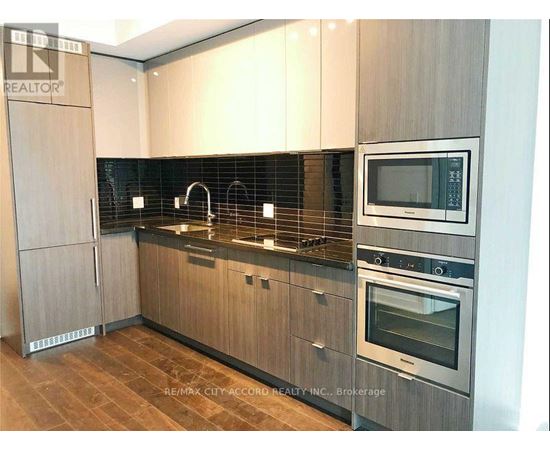 A modern kitchen with wooden cabinets and stainless steel appliances.
