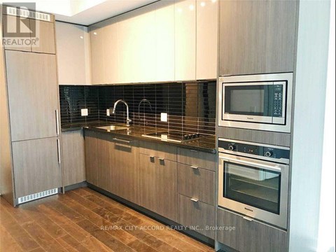 A modern kitchen with wooden cabinets and stainless steel appliances.