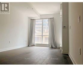 A spacious room with a large window and curtains.