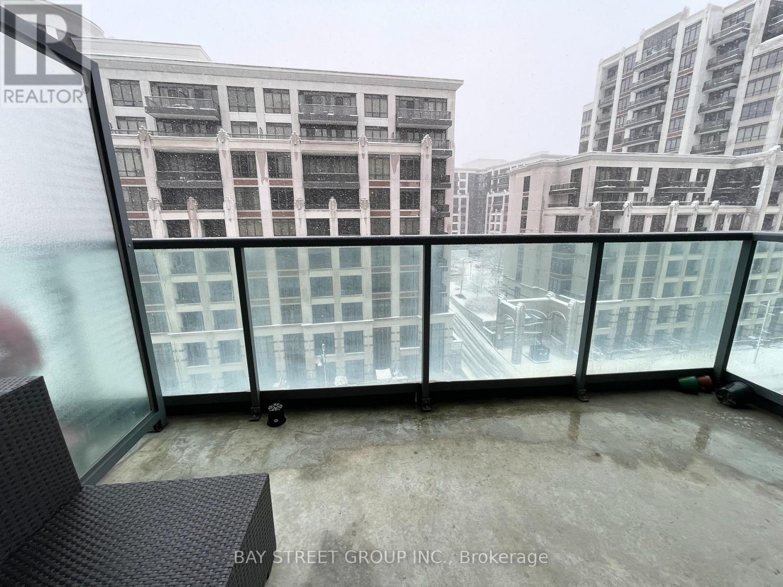 A balcony with a glass railing and a view of buildings.