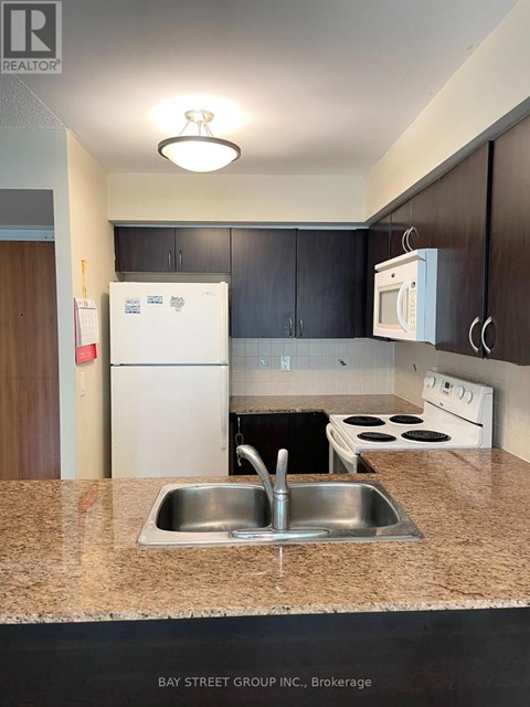 A kitchen with a sink and a refrigerator.