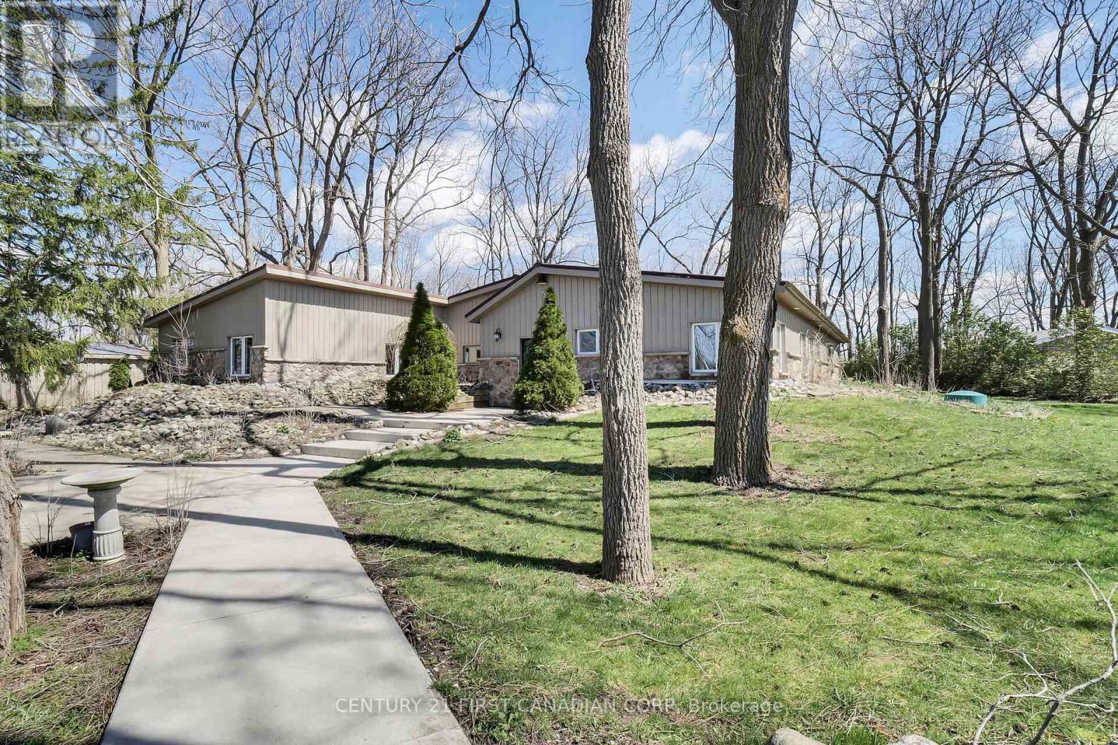 A residential area with a house, trees, and a sidewalk.