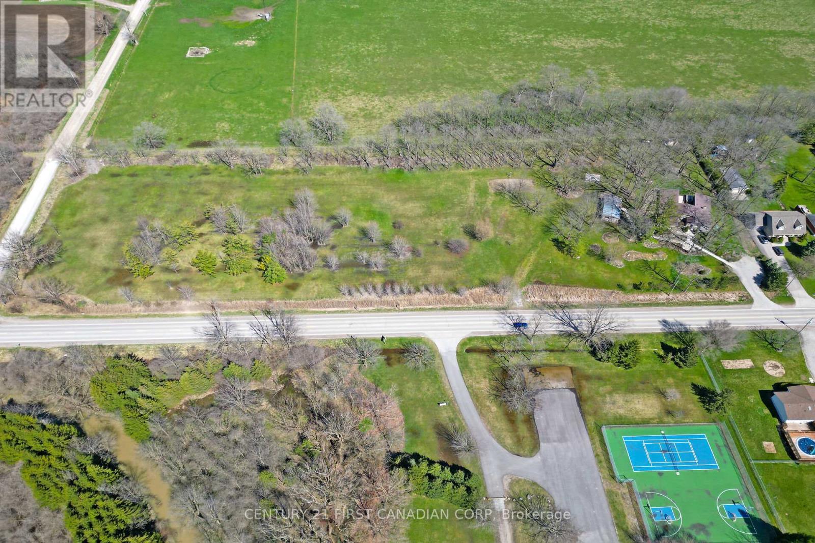 An aerial view of a residential area with a pool and tennis court.