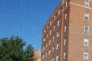 a tall brick building with a sidewalk in front of it