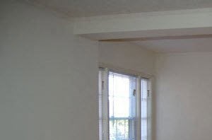 an empty room with a wooden floor and a window