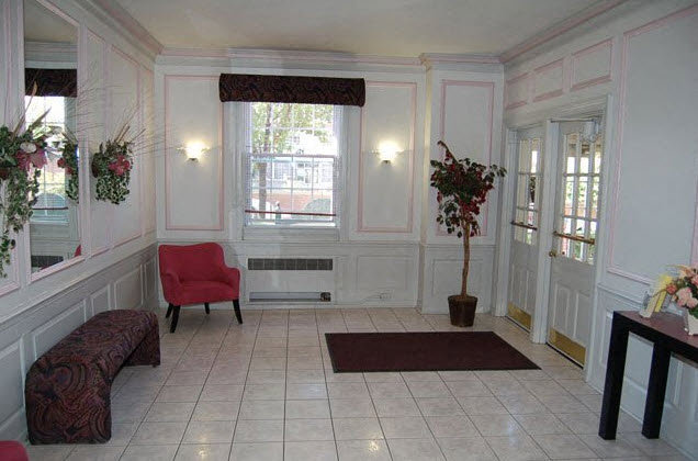 a living room with white walls and a red chair