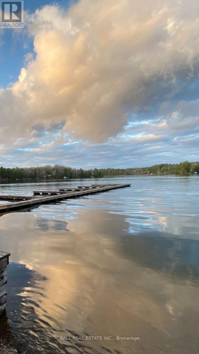 A body of water with a dock and a cloudy sky reflected in the water.
