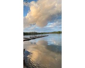A body of water with a dock and a cloudy sky reflected in the water.