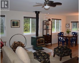 A living room with a wood stove and a fan.