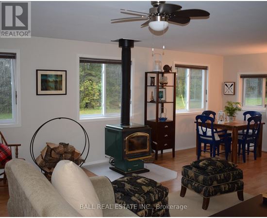 A living room with a wood stove and a fan.