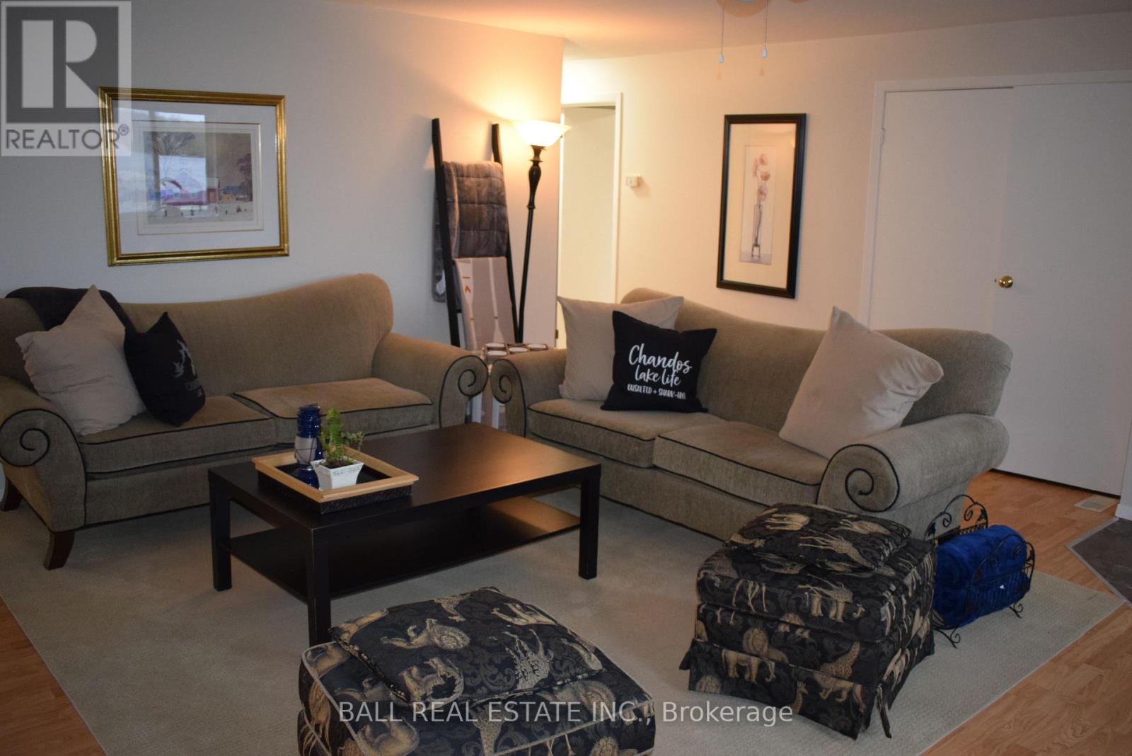 A living room with a couch, coffee table, and two pictures on the wall.